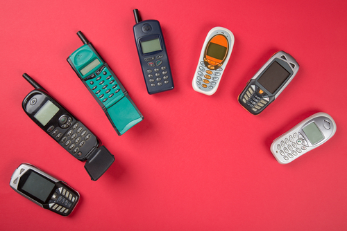 Old,Vintage,Mobile,Phones,On,Red,Background.